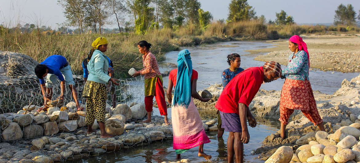Women build barriers in Nepal to prevent the river from overflowing and flooding nearby villages.
