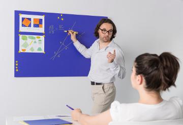 A teacher in front of a black board © EU