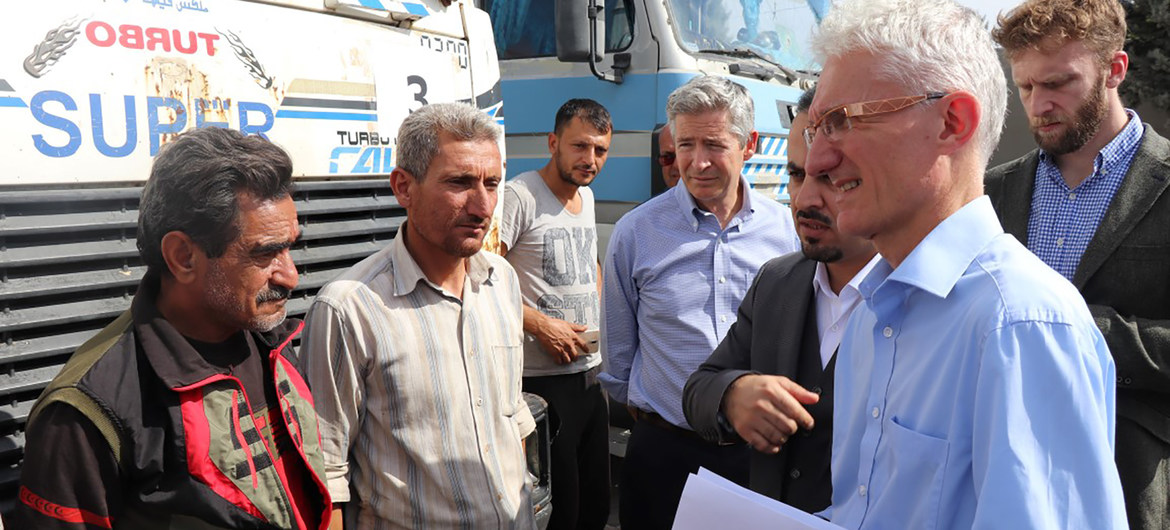In this file photo, UN Humanitarian Coordinator, Mark Lowcock (r) meets with a group of Syrian drivers on the Turkish side of the two countries' common border.