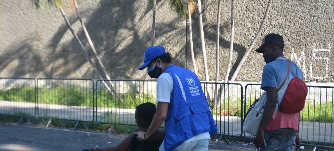 UNHCR staff assist a migrant at the Olympic Stadium in Tapachula, Chiapas, in November 2021.