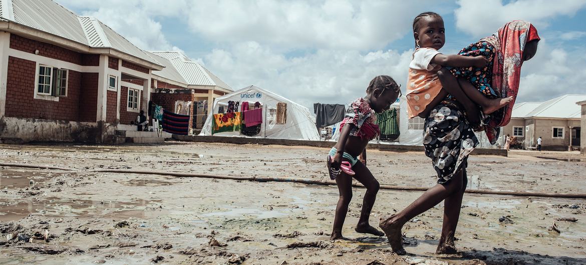 Children walk through the mud in a displaced persons camp in Maiduguri in northeast Nigeria.