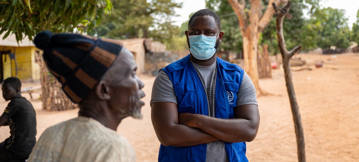 An IOM officer listens to the concerns of a community leader in a Gambian village.