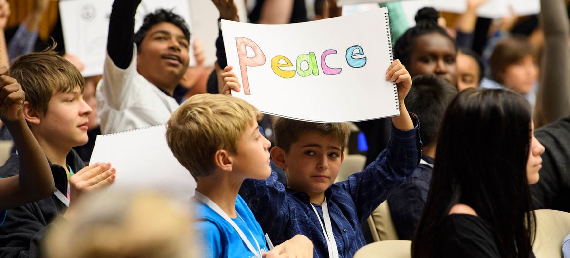 During a special event held to mark Universal Children's Day, youth from around the world hold signs calling for peace.