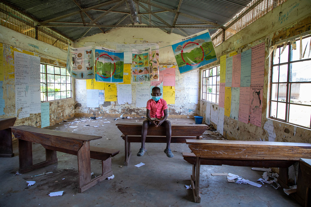 A twelve-year-old boy sits in the empty classroom of a school which was closed during the COVID-19 pandemic.