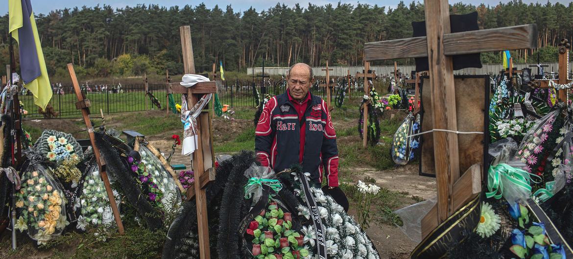 A man mourns his deceased best friend at a cemetery in Bucha, Ukraine.